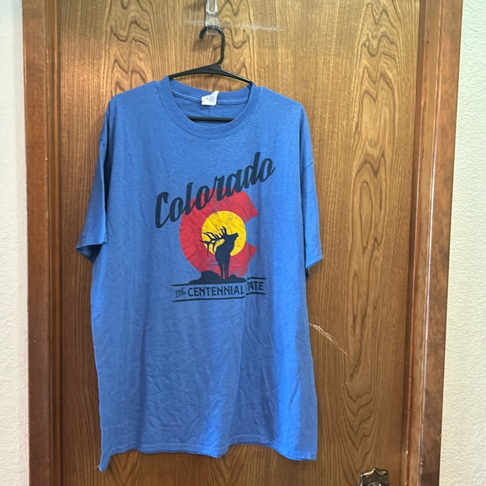 Blue Colorado shirt with moose on front with a red circle and a yellow backing
